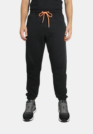 Pantaloni della tuta neri con elastico in vita, cordino arancione, tasche laterali e un piccolo logo sulla coscia sinistra.