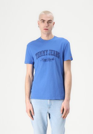 Blue cotton t-shirt with crew neck, featuring "TOMMY JEANS New York" text in dark blue, short sleeves, and a small logo on the sleeve.