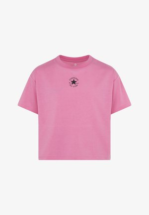 T-shirt cropped rosa feita de algodão, com decote redondo, mangas curtas e um logótipo preto impresso "Converse All Star" no peito.