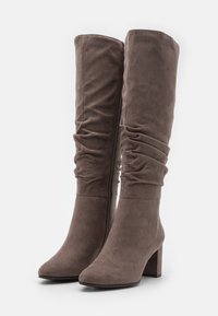 Botas altas de ante gris con tacones de bloque y cremalleras laterales, con un diseño holgado en la zona de la pantorrilla.