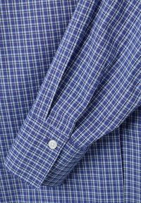 Camicia a maniche corte in tessuto a scacchi blu, con polsini a bottone, motivo a scacchi intricato e una miscela di tonalità di blu scuro e chiaro.