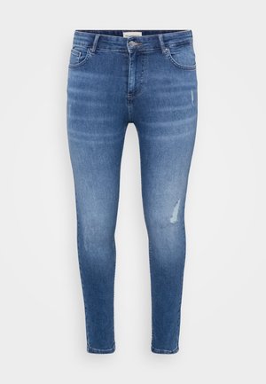 Schmale Jeans aus hellblauem Denim mit subtilen Abnutzungen, beschädigten Akzenten, fünf Taschen und einem Reißverschluss. Glatte Textur.