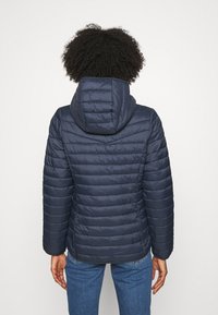 Navy puffer jacket with a hood, horizontal quilted pattern, and long sleeves. Soft, insulated material with a smooth finish and visible seams.