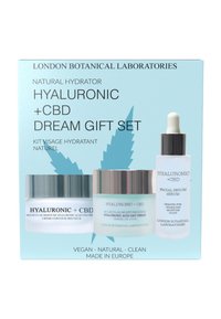 Zestaw prezentowy Hyaluronic + CBD Dream zawiera trzy produkty do pielęgnacji skóry w przezroczystych i matowych szklanych pojemnikach z srebrnymi i białymi akcentami na niebieskim opakowaniu.