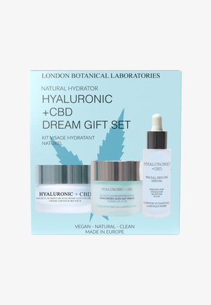 Zestaw prezentowy Hyaluronic + CBD Dream zawiera trzy produkty do pielęgnacji skóry w przezroczystych i matowych szklanych pojemnikach z srebrnymi i białymi akcentami na niebieskim opakowaniu.