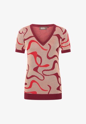 Top de punto de manga corta con cuello en V, que presenta espirales abstractas en rojo y marrón sobre un fondo beige claro. Puños y dobladillo acanalados.