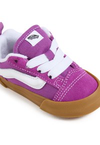 Baskets en daim violet avec des lacets blancs et une bande latérale blanche. Semelle en caoutchouc, bout rond et languette de talon renforcée.