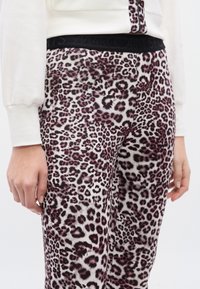 Φόρμες με λεοπάρ τύπωμα και μαύρη ελαστική μέση, με απαλή υφή και αποχρώσεις ροζ και λευκού στο ζωικό μοτίβο.