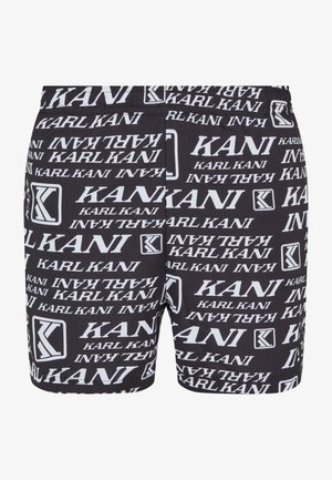 Shorts noirs avec un motif répétitif en blanc "KANI" et logo, dotés d'une taille élastique et d'une texture de tissu lisse.