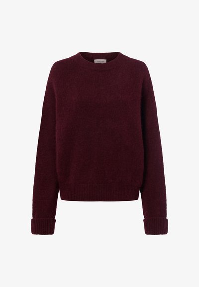 Pull tricoté rouge foncé avec manches longues et poignets, ourlet et encolure ronde côtelés, sur fond blanc.