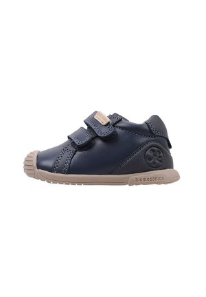 Zapatos para toddlers de cuero azul marino con dos correas de Velcro, suela de goma beige y un logo en el costado. Punta redonda con detalle de costura.