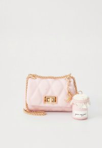 Rosa quiltad handväska med gulddetaljer, utrustad med en kedjerem och en dekorativ charm. Medföljer en liten behållare med lock.