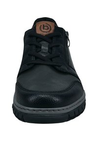 Schwarze Lederschuhe mit strukturiertem Obermaterial, versehen mit Schnürsenkeln, einem seitlichen Reißverschluss und einem braunen Logo-Patch an der Zunge. Graue Sohlenakzente.