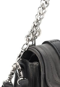 Sac en cuir noir avec une bandoulière en chaîne argentée métallique. Présente une finition texturée, des coutures visibles et un fermoir pour fixer la bandoulière.