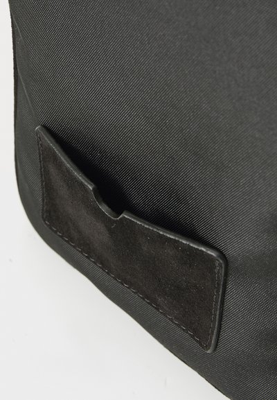 Geantă din material textil negru, cu un finisaj texturat, având un buzunar din piele suede neagră. Formă rectangulară, design minimalist.