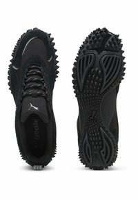 Le scarpe sportive nere presentano una tomaia testurizzata in suede e mesh, punta rotonda e suola esterna in gomma robusta con punte per una migliore aderenza.