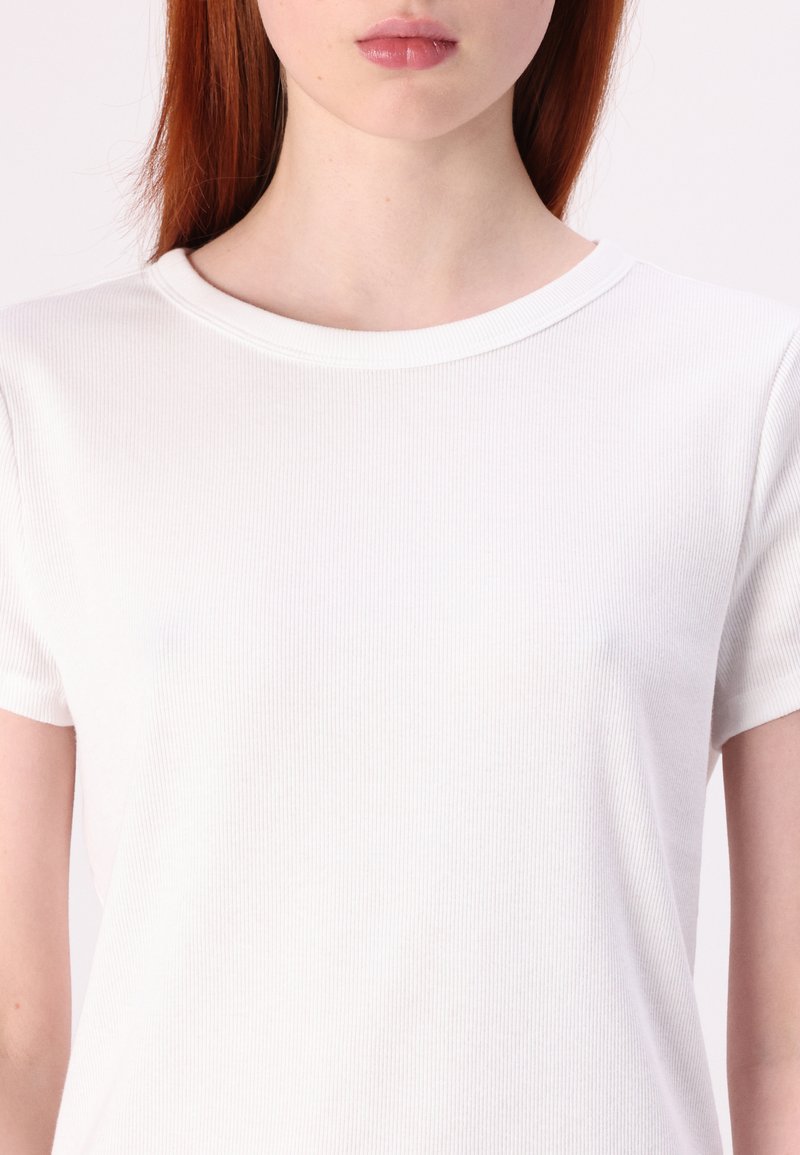 Weißes, geripptes T-Shirt mit kurzen Ärmeln und Rundhalsausschnitt. Der Stoff wirkt glatt und eng anliegend und betont ein einfaches und klassisches Design.