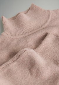 Pehme roosa tumesinine kampsun, millel on soonikuga kaelus, laotatud tasapinnale, näidates tekstuuri ja õmbluseid neutraalsel taustal.