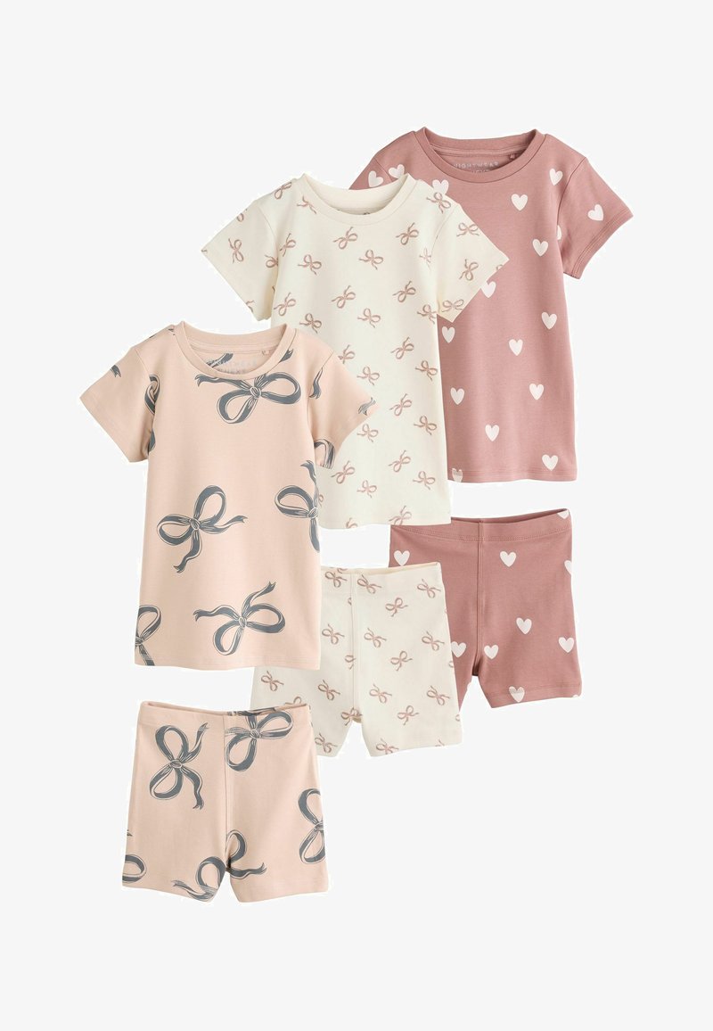 Trois ensembles de hauts à manches courtes et shorts assortis pour enfants, avec des motifs de nœuds et de cœurs en rose, crème et mauve.