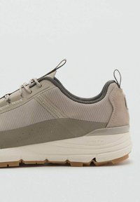 Beige vaelluskengät, joissa on tekstiili- ja mokkanahkaovi, joissa on teksturoitu muotoilu, vahvistettu kärki ja Vibram-pohja pidon takaamiseksi.