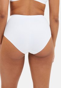 Bas de bikini taille haute blanc avec une texture lisse et des coutures minimes, présentant une coupe classique qui offre une couverture optimale.