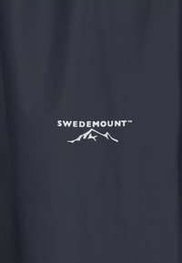 White Swedemount logo with stylized mountain graphic centered on dark blue fabric background.