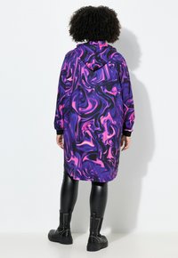 Hooded lange jas in paars en roze gedraaid patroon; gemaakt van stof met een gladde textuur; heeft lange mouwen en een ontspannen pasvorm.
