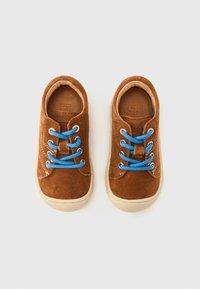 Καφέ σουέντ παπούτσια με μπλε κορδόνια, μπεζ καουτσούκ σόλες και στρογγυλεμ ένο σχέδιο μύτης. Υφή στην επιφάνεια και ραφές διακοσμητικές στα πλάγια.