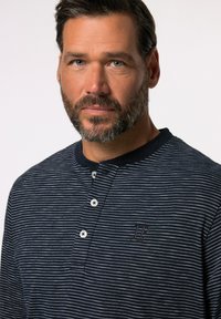 Marineblau gestreiftes Langarm-Henley-Shirt mit Knopfleiste und strukturiertem Stoff, ausgestattet mit einem kleinen gestickten Logo.