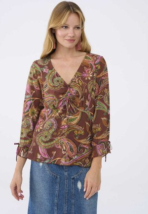 Bruine blouse met paisleypatroon, voorzien van een V-hals, driekwartmouwen met strikjes en een losse pasvorm. Zacht materiaal met levendige kleurenaccenten.