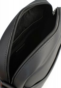 Borsa a spalla sintetica nera con chiusura a zip, dotata di un ampio interno, texture liscia e tasche interne per l'organizzazione.