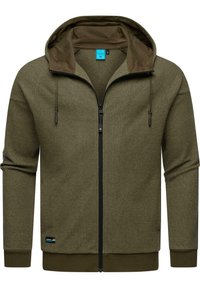 Sweat à capuche zippé vert olive en tissu texturé, avec capuche ajustable et accents de fermeture éclair noirs. Poignets et bas côtelés, avec un logo.