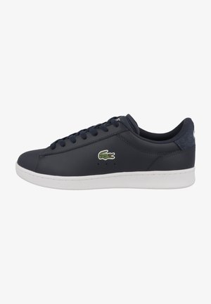 Sapatilha azul-marinho com parte superior em sintético liso, sola de borracha branca, design de atacadores e logótipo bordado em verde na lateral.