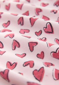 Světlounce růžová látka s motivem rozptýlených ručně kreslených červených srdcí vyznačených černým obrysem, vykazující jemnou texturu.