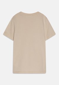 Beżowa koszulka z krótkim rękawem, wykonana z miękkiej bawełny, z okrągłym dekoltem i prostym dołem. Prosty design bez wzorów i grafik.