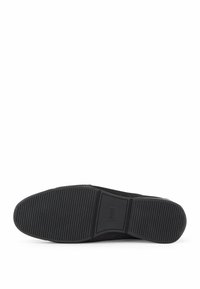Černá kožená obuv s texturovanou gumovou podrážkou, vybavená horizontálními hřebeny pro lepší uchopení a minimalistickým designem. Bez viditelných kovových částí nebo ozdob.