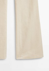 Pantalon en velours côtelé beige avec une texture côtelée verticale visible, montré de la mi-cuisse vers le bas, évasé légèrement au bas.