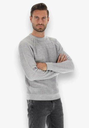 Maglione grigio a coste con maniche lunghe e scollo tondo, caratterizzato da un lavorato a maglia testurizzato e un taglio aderente. Abbinato a pantaloni grigi scuri.