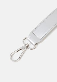 Cinturino metallico argento con finitura liscia e cuciture visibili, dotato di un gancio a moschettone in metallo argentato per il fissaggio.