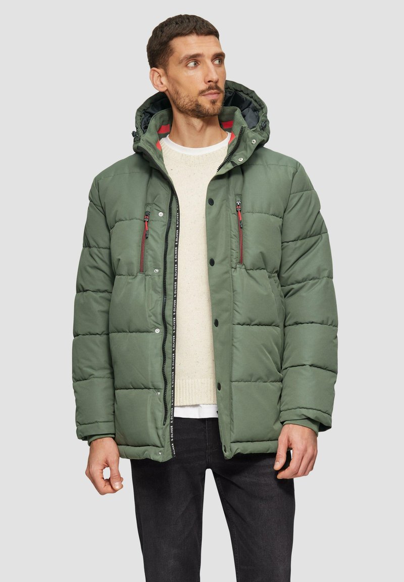 Groene pufferjack met capuchon, voorzien van rode accenten en voorzakken met rits. Gladde textuur met een boxy vorm, ontworpen voor warmte.