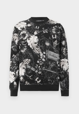 Melnā džemperī ar sarežģītu baltu ziedu un putnu būrīšu rakstu. Ribota apakšmala un apkakle, piedāvā brīvu piegriezumu un mīkstu auduma tekstūru.