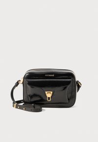 Black patent leather crossbody bag with gold hardware, zip closure, front pocket, and adjustable strap. Smooth texture with minimalist design.