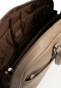 Beige leren tas met een gestructureerd oppervlak. Binnenin bevinden zich meerdere vakken en een ritsvak, gevoerd met donkerbruine stof.