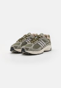 Baskets de sport grises et vert olive en matériaux mesh et suède, avec des accents beiges, des semelles texturées et trois rayures blanches.