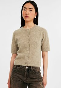 Korte mouwen, lichtbruine cardigan van zacht breisel met een ronde halslijn en zes knopen aan de voorkant.
