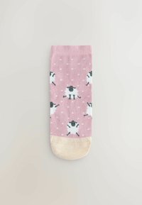 Lichtroze enkelsokken met een patroon van zwarte en witte schapen op een gestippelde achtergrond, met een crèmegekleurde teen.