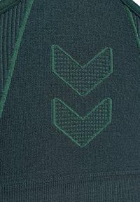 Dunkelgrüner gestrickter Stoff mit geripptem Muster, versehen mit zwei nach unten gerichteten Chevronmustern in einem etwas helleren Grün.