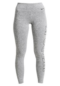 Szare legginsy z teksturowanej, elastycznej tkaniny. Posiadają wysoki pas i wyraźne logo "NIKE" nadrukowane pionowo na lewej nogawce.