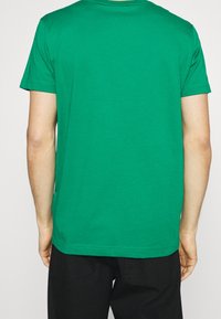 Zielony T-shirt z bawełny, z krótkim rękawem, okrągłym dekoltem i prostym krojem; subtelne detale przeszycia i gładka faktura.