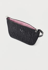Μαύρο κα πιτονέ πορτοφολάκι χειρός με ασημένιο λογότυπο Puma, ροζ εσωτερική επένδυση και ασημένια τσισαριστή φερμουάρ, τοποθετημένο σε λευκό φόντο.